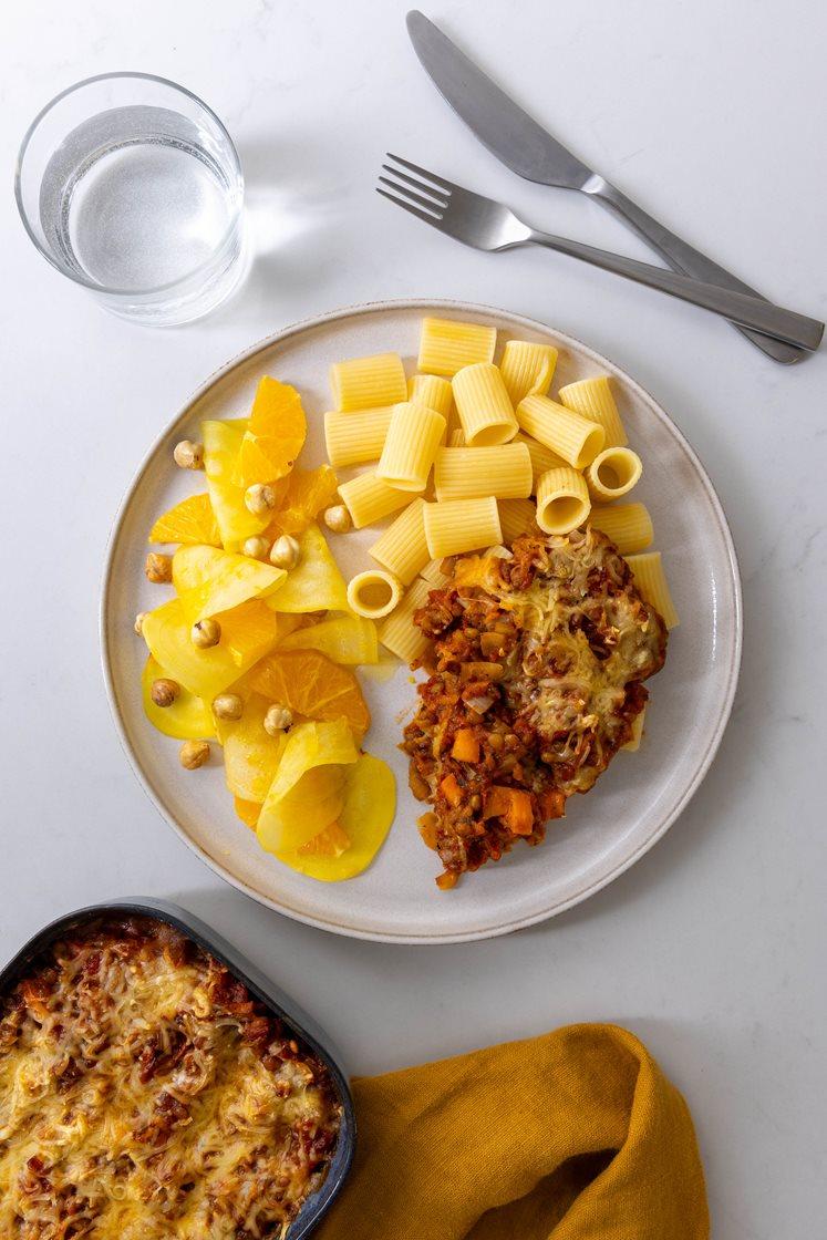 Gratinert linsebolognese-form, servert med appelsin- og betesalat med ristede hasselnøtter