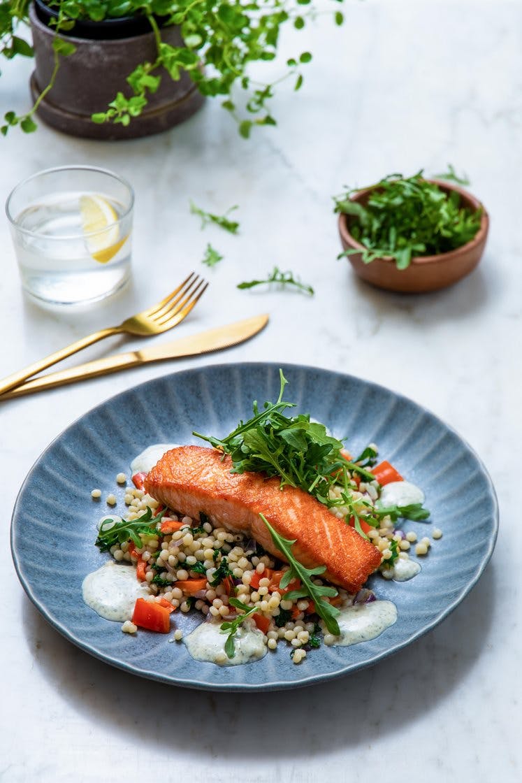 Stekt laksefilet med couscous, paprika og grønnkål, servert med tyrkisk yoghurt og ruccola