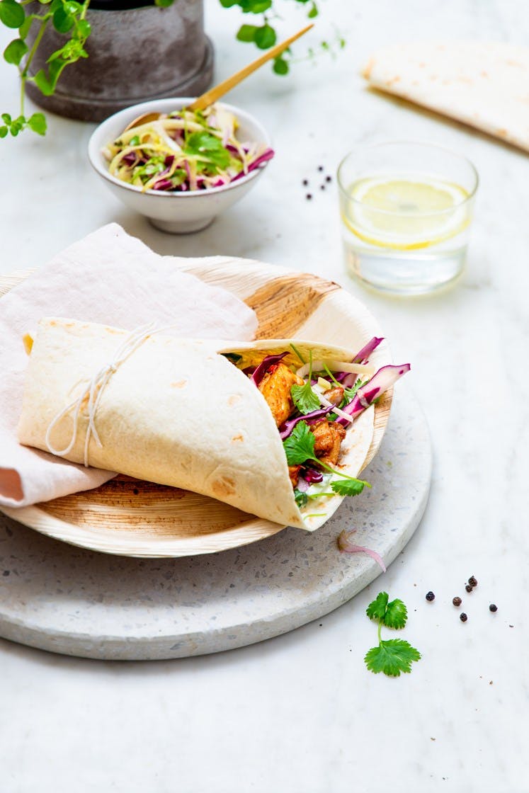 Indisk wrap med butter chicken og kålsalat, servert med tomatraita