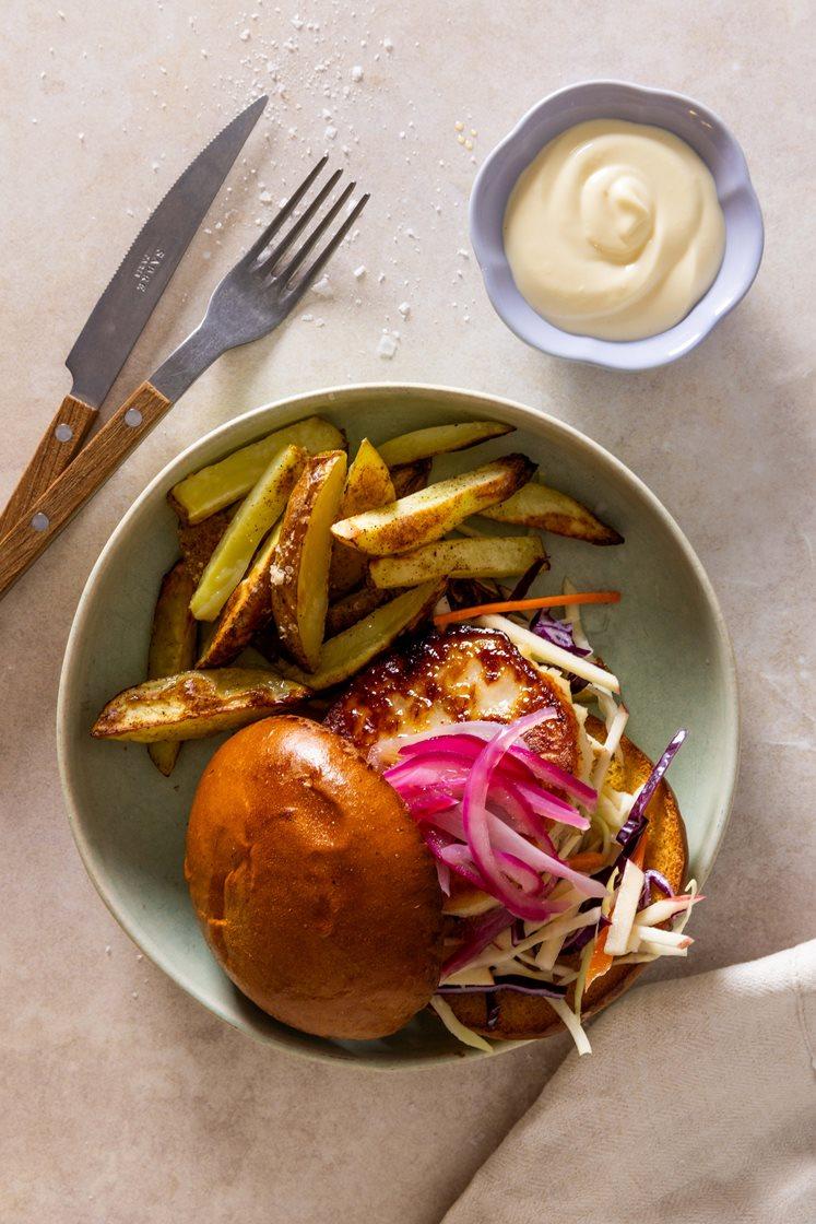 Fiskeburger i brioche servert med eple-coleslaw, syltet rødløk, potetfries og aioli