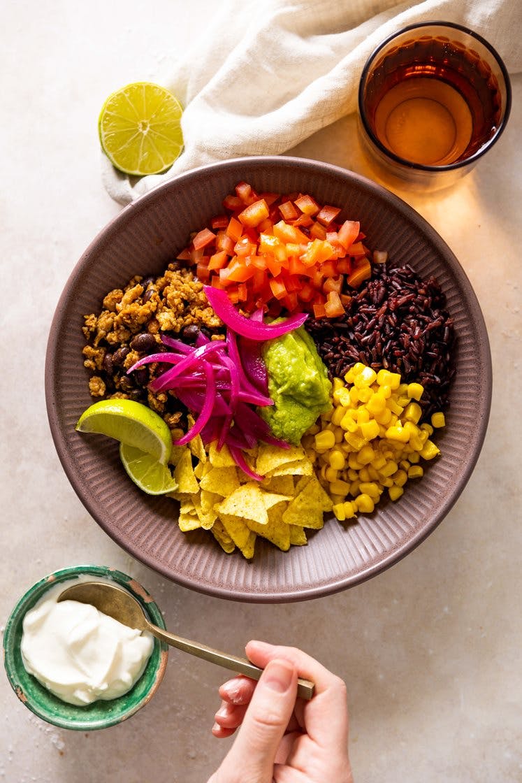 Meksikansk bowl med tacokrydret kyllingkjøttdeig, syltet rødløk, avokadohummus og tortillachips